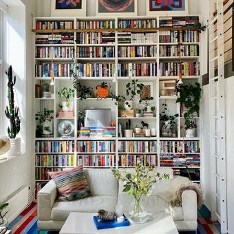 Small living room with floor-to-ceiling bookshelves showing smart vertical storage